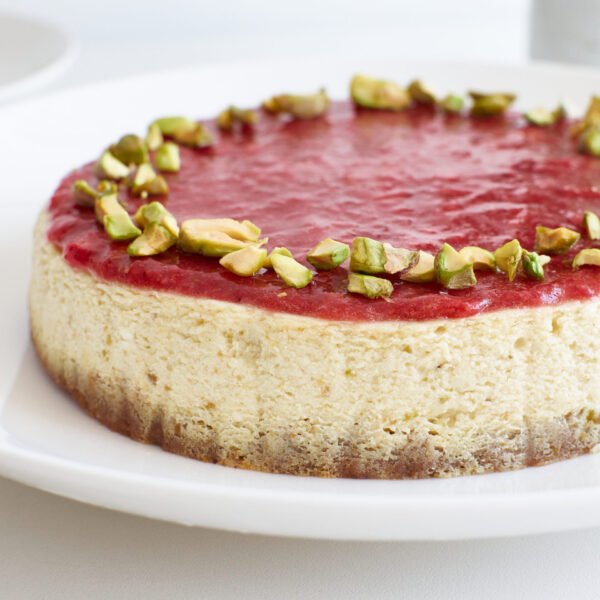 Cheesecake cremoso y suave con una capa de mermelada de fresas frescas en la parte superior.