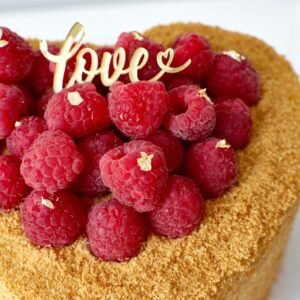 Torta Medovik en forma de corazón con frambuesas frescas y detalles en pan de oro de AnnyCake.